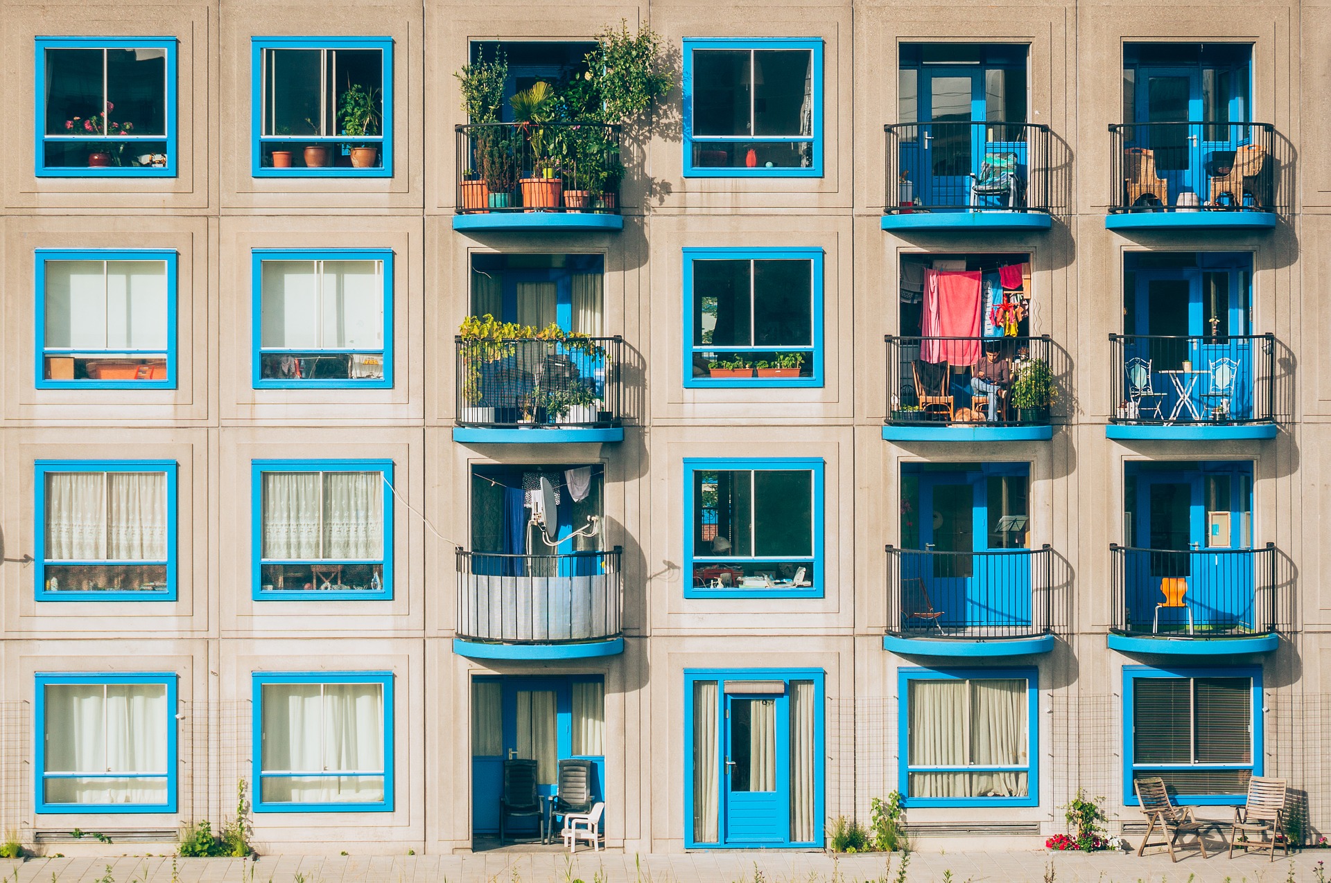 Fachada de um prédio com várias janelas mostrando como é morar em apartamento.